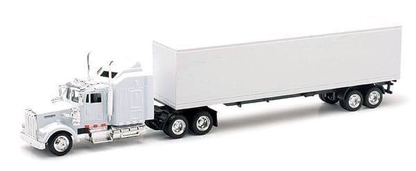A white semi truck with its trailer on the back.