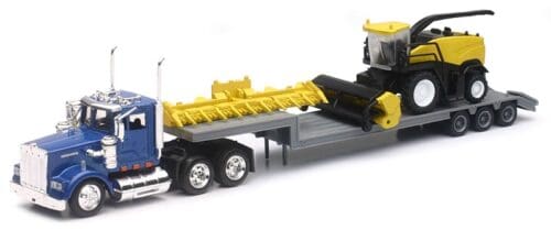 A toy tractor trailer with a yellow and black plow.