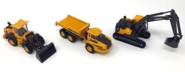 A toy dump truck and tractor are on the floor.