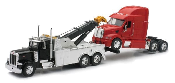 A red tow truck is towing a white trailer.