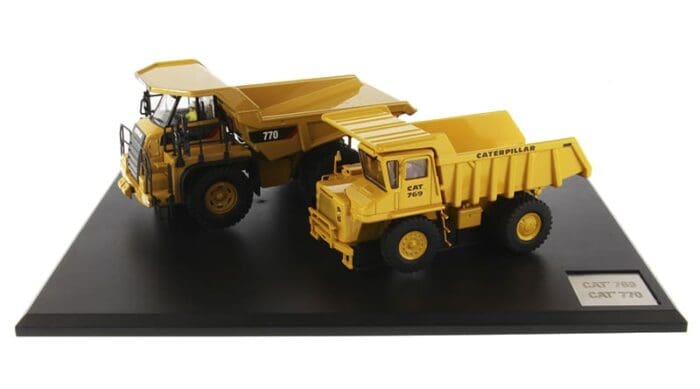 A yellow dump truck and a black cat tractor on display.
