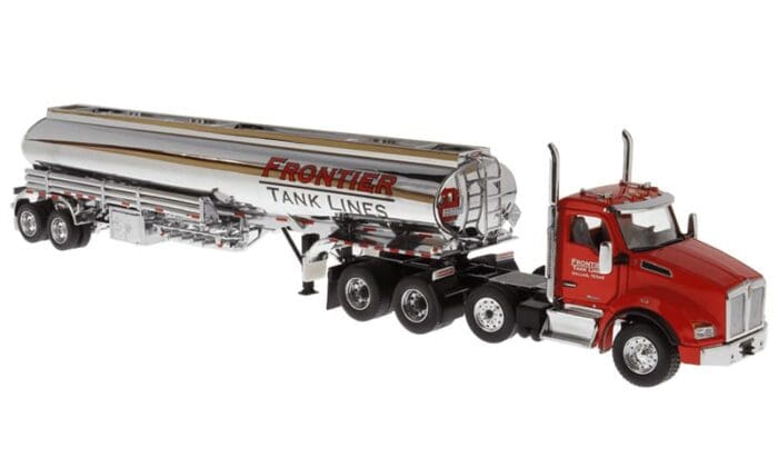 A red and silver truck is parked next to the tanker trailer.