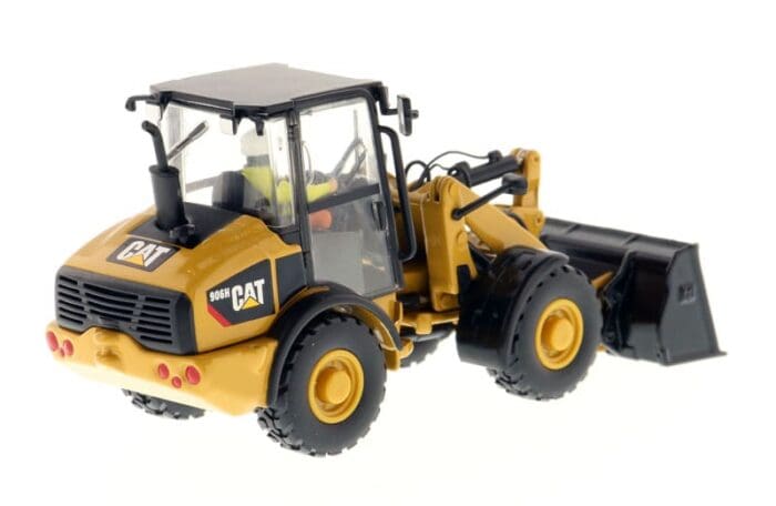 A yellow and black cat wheel loader with a plow.