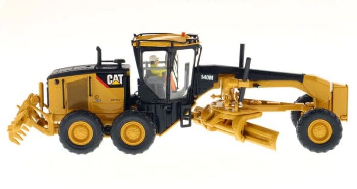 A yellow and black cat tractor with a plow.
