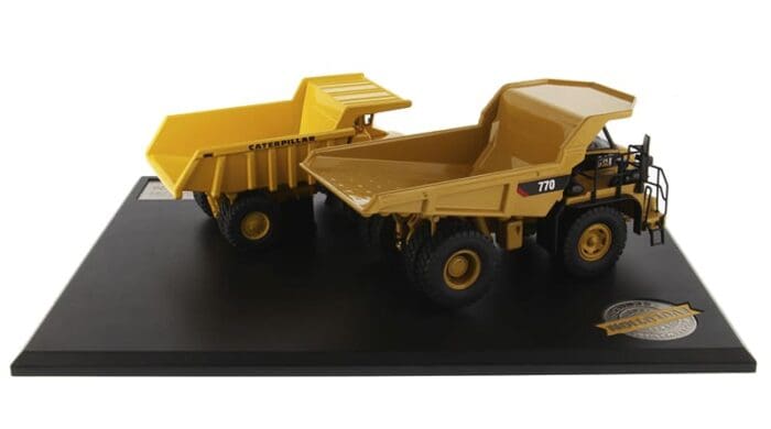 A yellow dump truck and trailer on display.