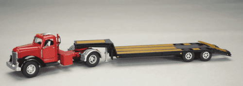 A toy semi truck with flatbed trailer on the back.