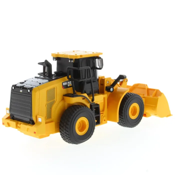 A yellow and black toy tractor on top of a white table.