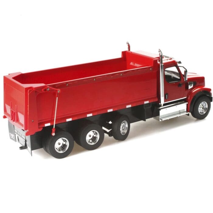 A red dump truck is parked on the side of the road.