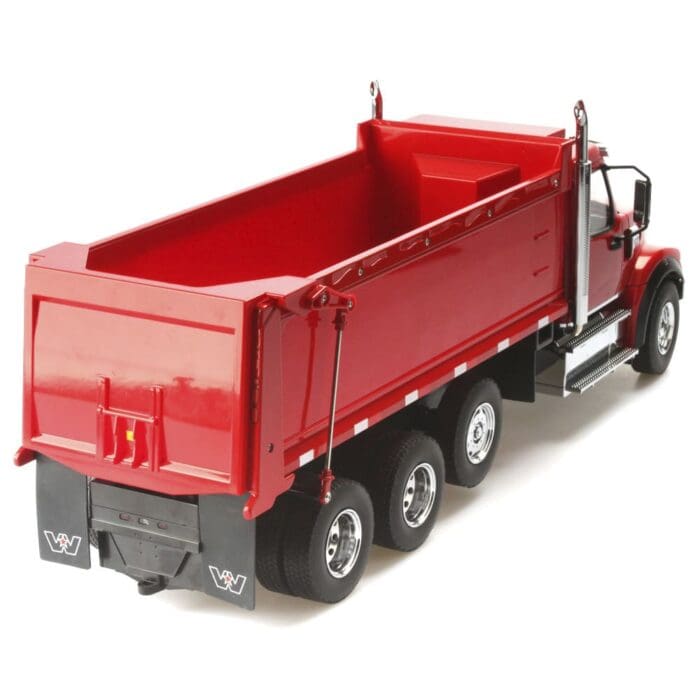 A red dump truck is parked on the side of the road.